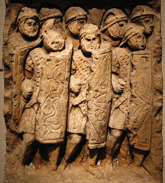 Roman legionnaires stand shoulder to shoulder.